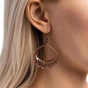 Beautiful Bronze earrings with flowers cut out within the earring .